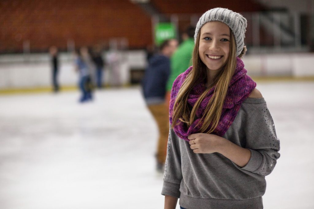 Teen girl ice skating and smiling